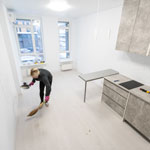 person cleaning wall in modern kitchen