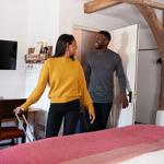 couple smiling inside a cozy room enjoying their stay in a charming space